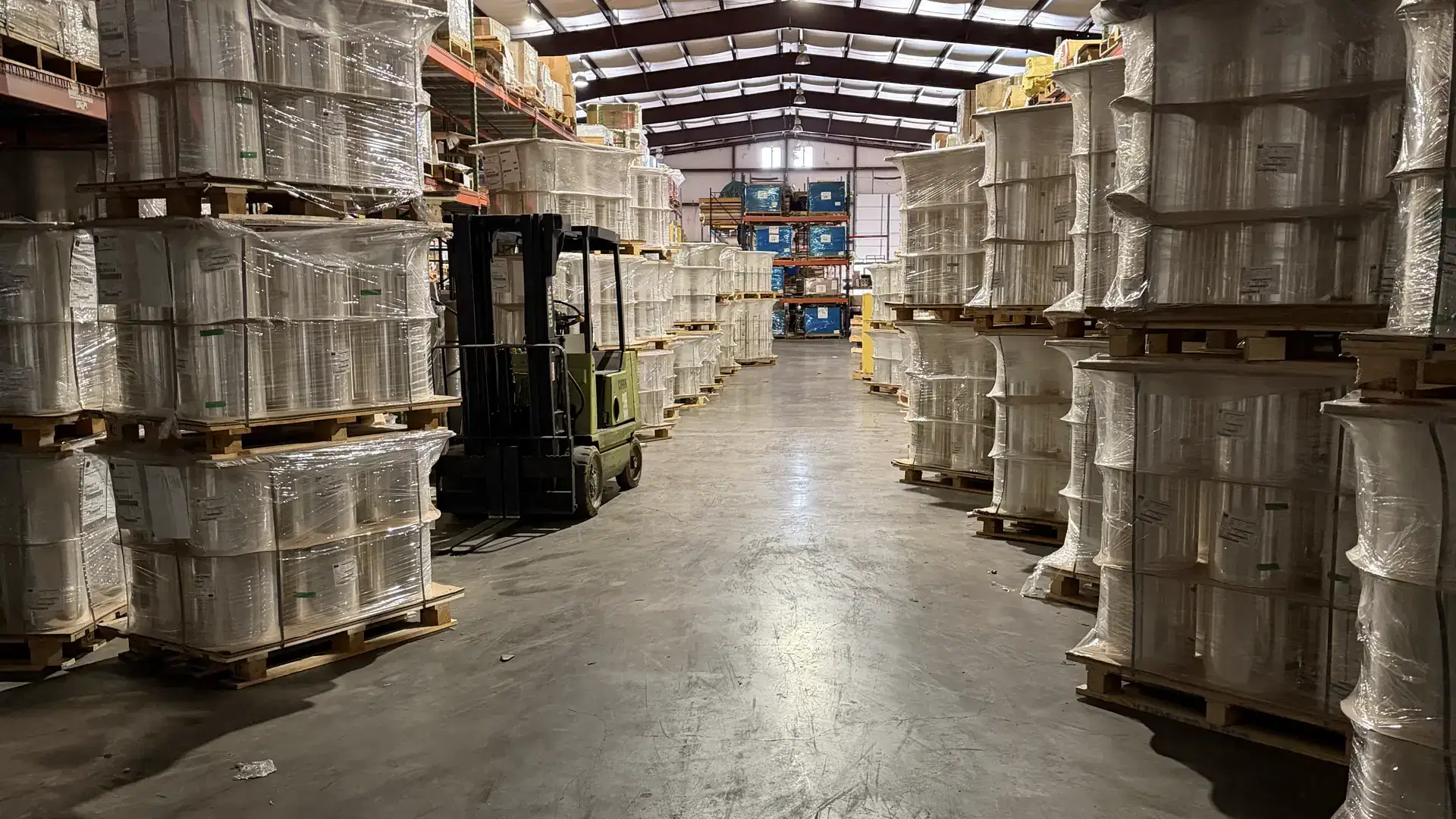 Pallets of print-grade film rolls lining an aisle of the K&R Plastics Austin warehouse